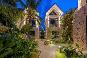 eine Außenansicht eines Hauses mit Garten in der Unterkunft Coco Island Resort Ninh Binh in Ninh Bình