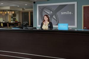 a woman is standing behind a reception desk at Hampton Inn Louisville/I-65/Brooks Road in Brooks