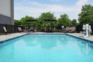 una gran piscina azul con sillas y sombrillas en Hampton Inn Louisville/I-65/Brooks Road, en Brooks