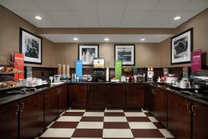 a kitchen with wooden cabinets and a checkered floor at Hampton Inn Louisville/I-65/Brooks Road in Brooks