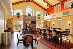 Hampton Inn & Suites Phoenix/Scottsdale في سكوتسديل: غرفة طعام مع طاولات وكراسي في مطعم