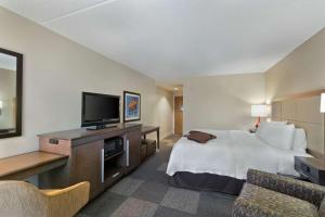 Hampton Inn & Suites Phoenix/Scottsdale في سكوتسديل: غرفة فندقية بسرير وتلفزيون بشاشة مسطحة