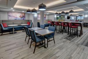 a lobby with tables and chairs and a bar at Hampton Inn New Albany Louisville West in New Albany