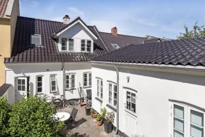 una casa blanca con techo negro en Professor Labri Apartments, en Odense