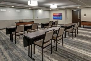 a conference room with tables and chairs and a piano at Hampton Inn New Albany Louisville West in New Albany