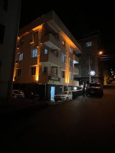 a building with cars parked in a parking lot at night at NOKTA SUITE APART in Pelitli