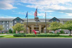 a hotel with flags in front of a building at Homewood Suites by Hilton Louisville-East in Louisville
