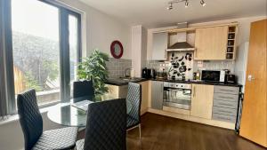 a kitchen with a table and some chairs in a room at 2 Bed Flat Near Deansgate in Manchester