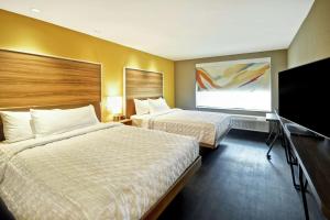 ein Hotelzimmer mit 2 Betten und einem Flachbild-TV in der Unterkunft Tru By Hilton Louisville Airport in Louisville