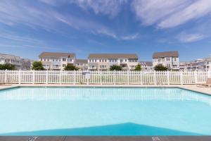 een zwembad met een hek en een aantal appartementen bij Seaside Village --- #3 in Ocean City