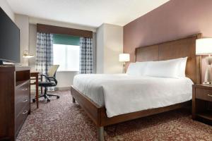 a hotel room with a bed and a desk and a computer at Hilton Garden Inn Louisville Downtown in Louisville