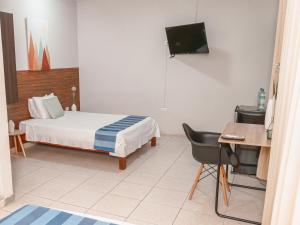プカルパにあるLeveint Executive Hotelのベッドルーム(ベッド1台、デスク、テレビ付)