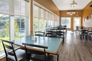 - une salle à manger avec des tables, des chaises et des fenêtres dans l'établissement Hôtel Marineau Mattawin, à Trois Rives