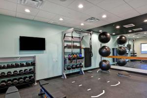 a fitness room with a gym with a television and weights at Tru By Hilton Shepherdsville Louisville South in Shepherdsville