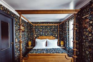a bedroom with a bed with floral wallpaper at Hôtel Eldorado Paris in Paris