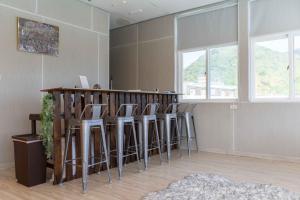 a bar with stools in a room with windows at 20ft Sea Attic in Green Island