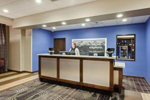 a woman standing at a bar in a hotel lobby at Hampton Inn Seattle/Everett Downtown in Everett