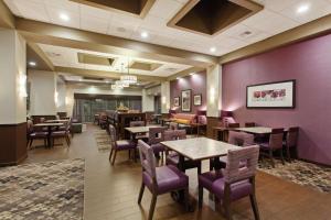 un restaurante con mesas y sillas de madera y paredes púrpuras en Hampton Inn Seattle/Everett Downtown, en Everett