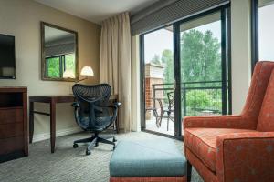 um quarto de hotel com uma secretária, uma cadeira e uma janela em Hilton Garden Inn Seattle/Issaquah em Issaquah