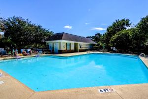 a large blue swimming pool in front of a house at Barefoot Memories in North Myrtle Beach