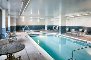 - une piscine avec des chaises et une table dans une chambre d'hôtel dans l'établissement Hampton Inn & Suites by Hilton Seattle/Northgate, à Seattle