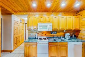 uma cozinha com armários de madeira e um forno de fogão branco em Silver Lodge B em Granby