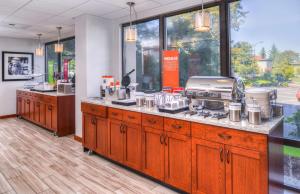 a kitchen with wooden cabinets and a counter with a appliance at Hampton Inn Seattle Airport in SeaTac