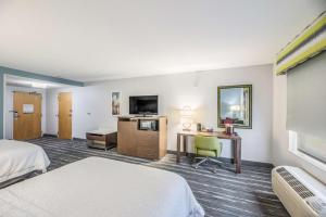 ein Hotelzimmer mit einem Bett und einem Schreibtisch in der Unterkunft Hampton Inn Oakland-Hayward in Hayward