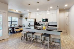 a kitchen with white cabinets and a island with bar stools at Tanglewood Retreat in Spring Branch