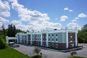 a large building with a car parked in a parking lot at Hampton Inn & Suites Berkshires-Lenox in Lenox