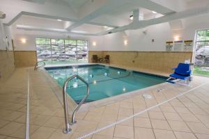 una gran piscina con una silla azul y una silla en Hampton Inn & Suites Berkshires-Lenox, en Lenox
