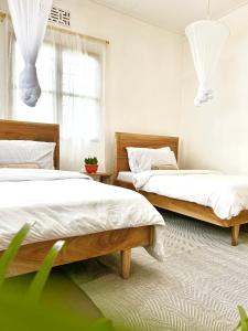 1 dormitorio con 2 camas y ventana en Goodtimewithfar House, en Moshi