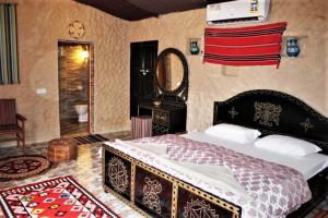 a bedroom with a large bed and a mirror at Al Reem Desert Camp in Jalan Bani Buhassan