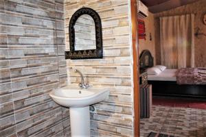 a bathroom with a sink and a bedroom with a bed at Al Reem Desert Camp in Jalan Bani Buhassan