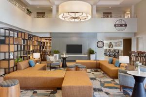 a lobby with couches and a tv and a library at DoubleTree by Hilton Campbell - Pruneyard Plaza in Campbell