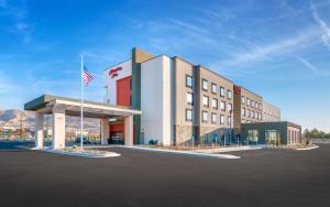 un hotel con bandera americana en un estacionamiento en Hampton Inn Draper Salt Lake City, Ut, en Draper