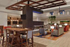 a lobby with a table and chairs and a fireplace at Embassy Suites By Hilton South Jordan Salt Lake City in South Jordan