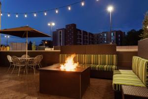 a fire pit on a rooftop patio with a table and chairs at Home2 Suites by Hilton Salt Lake City-Murray, UT in Murray