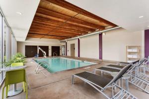 a pool in a room with chairs and a table at Home2 Suites by Hilton Salt Lake City-Murray, UT in Murray