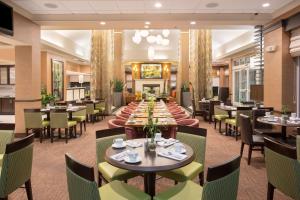 une grande salle à manger avec des tables, des chaises et une table dans l'établissement Hilton Garden Inn Salt Lake City/Layton, à Layton