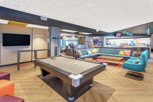 a billiard room with a pool table and couches at Tru By Hilton Salt Lake City Midvale in Midvale