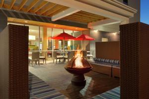 un patio con sofá y una mesa con sombrillas rojas en Home2 Suites by Hilton Lehi/Thanksgiving Point, en Lehi