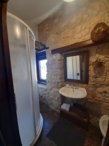 y baño de piedra con lavabo y ducha. en Antica Dimora Historic Building en Enna