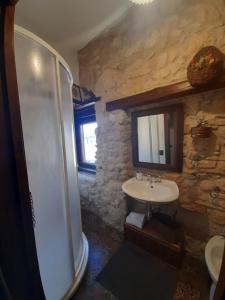 a stone bathroom with a sink and a shower at Antica Dimora Historic Building in Enna