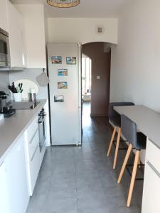 a kitchen with a refrigerator and a table and chairs at Chez kary in Saint-Cyr-sur-Mer