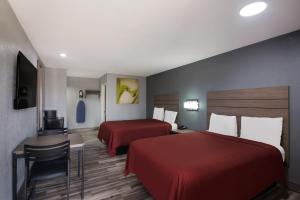 ein Hotelzimmer mit 2 Betten, einem Tisch und Stühlen in der Unterkunft Americas Best Value Inn Buda in Buda