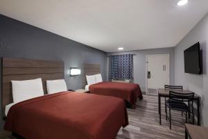 Postel nebo postele na pokoji v ubytování Americas Best Value Inn Buda