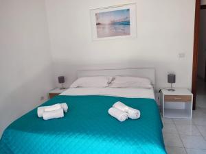 ein Schlafzimmer mit einem Bett mit zwei Handtüchern darauf in der Unterkunft Tramonto Apartment Seaview in Santa Domenica