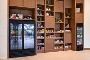 a grocery store with a refrigerator and shelves of food at Home2 Suites By Hilton Anaheim Resort in Anaheim
