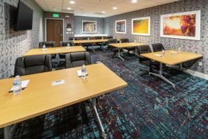 une salle de conférence avec des tables et des chaises en bois dans l'établissement Hampton Inn & Suites Santa Maria, à Santa Maria